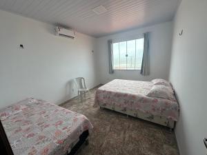 a bedroom with two beds and a window at Casa de praia in São-José-do-Ribamar