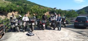 um grupo de homens ao lado de motocicletas em uma estrada em Apartman na Drini em Foca