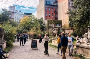 The Nolita Express Hostel في نيويورك: مجموعة من الناس يتجولون في حديقة بها تماثيل