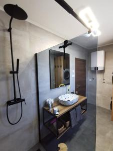 ein Bad mit einem Waschbecken und einem Spiegel in der Unterkunft Guest accommodation house Greta in Tribunj