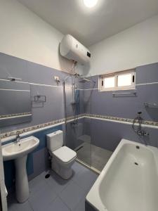 a bathroom with a toilet and a sink and a shower at Zhuraj Apartments in Shkodër +31 photos