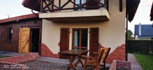 a table and two chairs sitting in front of a house at Domek letniskowy nad jeziorem Mazury in Ostróda +5 photos