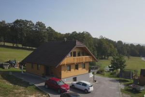a house with two cars parked in a parking lot at Snoopy House in Žužemberk