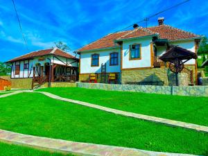 una casa con un césped verde delante de ella en Etno selo Stanojevic, en Boljevac