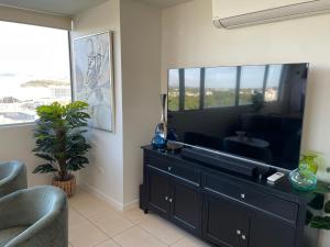 Una televisión o centro de entretenimiento en Penthouse Townsville