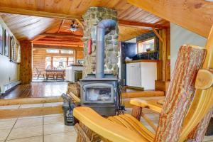 ein Wohnzimmer mit einem Kamin in einer Blockhütte in der Unterkunft Saranac Lake Cabin with Deck Pets Welcome! in Saranac Lake