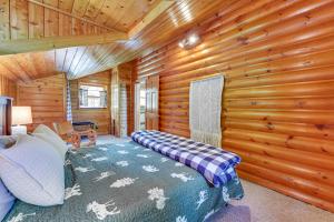 ein Schlafzimmer mit einem Bett in einem Blockhaus in der Unterkunft Saranac Lake Cabin with Deck Pets Welcome! in Saranac Lake
