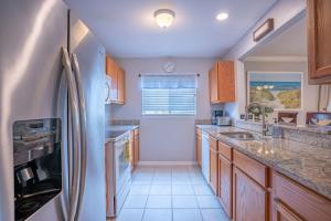 een keuken met houten kasten en een koelkast bij Lovely 3 bedroom first floor condo on golf course in Sarasota