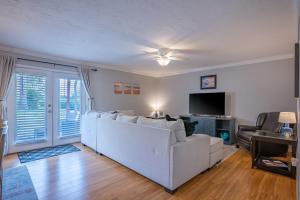 een woonkamer met een witte bank en een tv bij Lovely 3 bedroom first floor condo on golf course in Sarasota