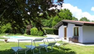 eine Villa mit einem Pool und Stühlen im Hof in der Unterkunft Villa Giorgia in Borgo Val di Taro