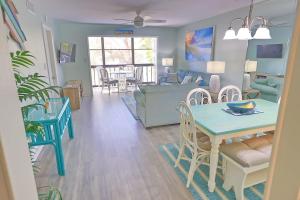 a living room with a table and a dining room at Updated Condo with Pool, Walk to Crescent Beach & Restaurants! in Sarasota