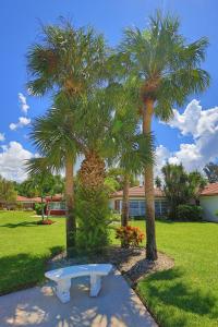 a park with two palm trees and a bench at Updated Condo with Pool, Walk to Crescent Beach & Restaurants! in Sarasota