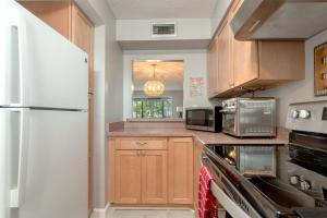 eine Küche mit Holzschränken und einem weißen Kühlschrank in der Unterkunft 2 bed 2 bath centrally located on Siesta Key in Sarasota