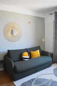 ein Wohnzimmer mit einem grünen Sofa und einem Spiegel in der Unterkunft SweetHomeVersailles 5mn walk from the Palace in Versailles