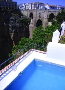a blue swimming pool with a view of a castle at Hotel Montelirio in Ronda