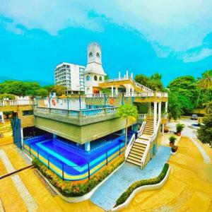 - un bâtiment avec une piscine d'eau en face dans l'établissement SGH Castillo Aqua, à Santa Marta