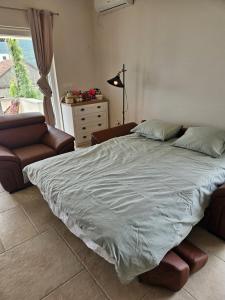 ein Schlafzimmer mit einem Bett und einer Couch und einem Fenster in der Unterkunft VanjAna 2 in Ðenovići