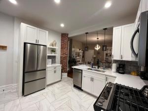 a kitchen with white cabinets and a stainless steel refrigerator at 2 BR Totally Renovated and Chic in Columbus