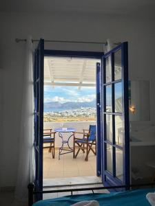 uma porta aberta para um pátio com uma mesa e cadeiras em Kapetan Giannis em Adamas