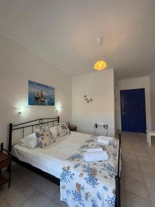 um quarto com uma cama com um edredão azul e branco em Kapetan Giannis em Adamas