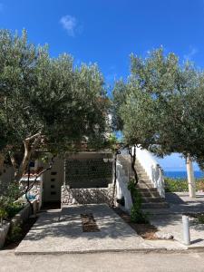 a building with trees and stairs with the ocean in the background at Apartmani "Nikola" Seaview - Ivan Dolac, Hvar in Ivan Dolac