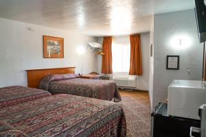 um quarto de hotel com duas camas e uma janela em Swiss Holiday Lodge em Mount Shasta