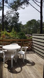 ラカノーにあるVitanova Sunset Lacanau Océanの木製デッキ(白いテーブルと椅子付) +2枚の写真