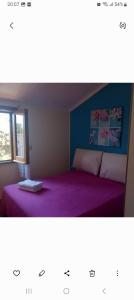 a bedroom with a purple bed and a window at Apartment Mini Monaco in Castelluzzo