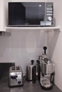 een keuken met een koffiezetapparaat en een magnetron bij SweetHomeVersailles 5mn walk from the Palace in Versailles