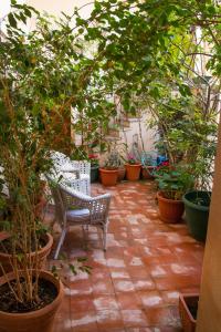 a garden area with a table, chairs, and plants at Palazzo Spagna in Syracuse