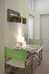 a dining room table with two green chairs at Palazzo Spagna in Siracusa