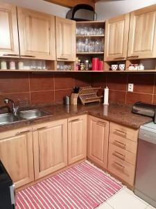 a kitchen with wooden cabinets and a sink at Chata Porubka in Liptovský Mikuláš