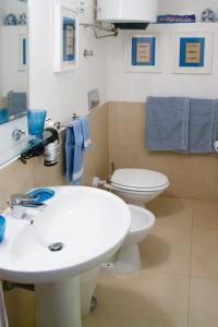 a bathroom with a white sink and a toilet at Palazzo Spagna in Siracusa