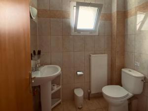 a bathroom with a white toilet and a sink at Apartments Thomoglou in Keramoti +15 photos