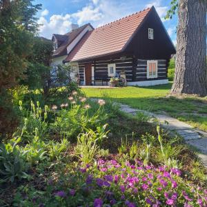 a house with a garden with flowers in front of it at Chalupa Líšnice in Sepekov