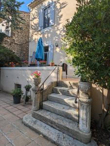 a staircase leading to a house with a blue umbrella at Rougetomette in Nîmes