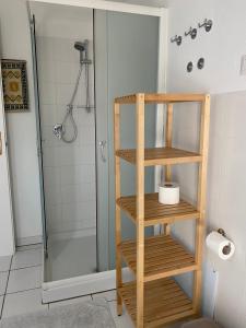 een badkamer met een douche en een houten boekenplank bij Casa Daniela in Torre delle Stelle