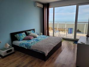 a bedroom with a bed with a view of the ocean at SKY INFINITY in Balchik