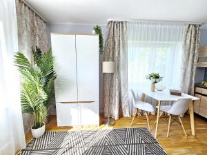 Cozy apartment close to the sea! في تالين: غرفة طعام مع خزانة بيضاء وطاولة وكراسي