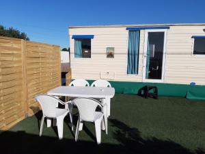a table and chairs on a patio with a caravan at Franceses in Chiclana de la Frontera