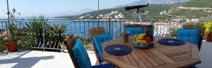 a wooden table with a bowl of fruit on a balcony at Apartment Carpe Diem with the best sea view, Utjeha Montenegro Mediterranean Eu in Masline +24 photos