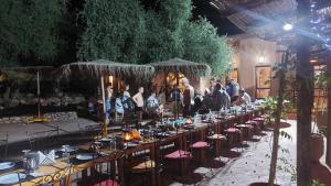 Un groupe de personnes autour d'une longue table dans l'établissement Paradis Nomade, à Azrarag