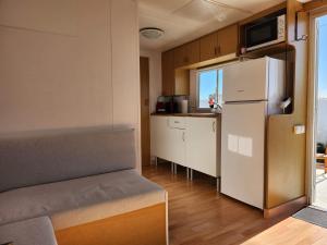 a small kitchen with a refrigerator and a table at Franceses in Chiclana de la Frontera