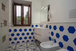 une salle de bain bleue et blanche avec des toilettes et un lavabo dans l'établissement Belvedere Rooms, à Marina di Camerota 29 autres photos