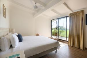 a bedroom with a bed and a large window at Hotel Perla de la Playa in Tamarindo