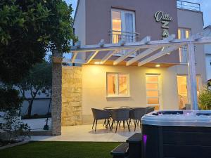 un patio con sillas y una mesa frente a una casa en Villa Zara, en Trogir