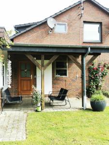 a brick house with a patio with two chairs at Kleine Auszeit in Amelinghausen