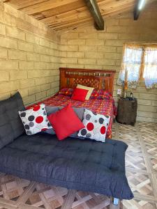 a bedroom with a bed with pillows on it at Casita de campo in Ocoyoacac