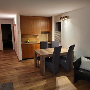 Residence Edelweiss في بلوالد: مطبخ وغرفة طعام مع طاولة وكراسي خشبية