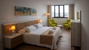una camera da letto con un letto e due sedie verdi di Alojamientos VEN -Vista Extremadura Norte a Plasencia Altre 139 foto